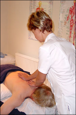Emily Alexander examining the dorsal spine of a male patient at the Backworking Osteopathic Practice in Barnsbury, Islington, London N1